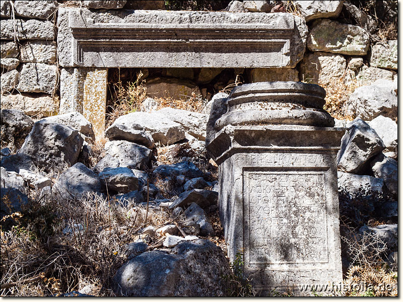 Termessos in Pisidien - Fuß einer Säule auf der Kolonnadenstraße; dahinter ein Eingang zu einem Geschäftshaus